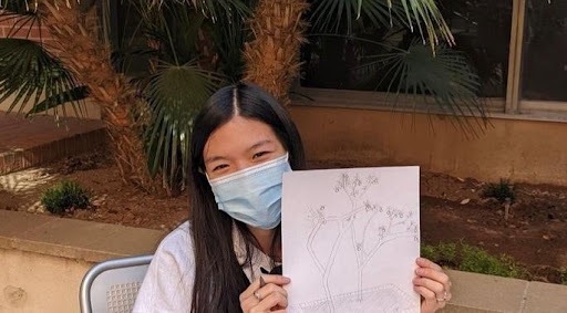 Jodie holding up a drawing of some trees