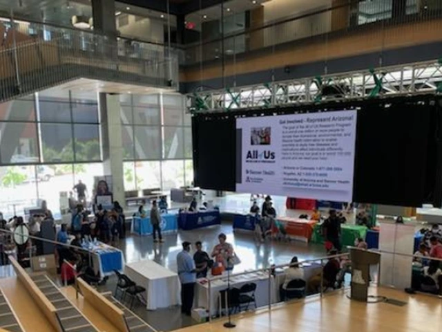 A wide-angle photo of the event, showing groups of people gathered around information tables.