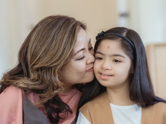 Portrait of Mother Kissing her Special Needs Daughter