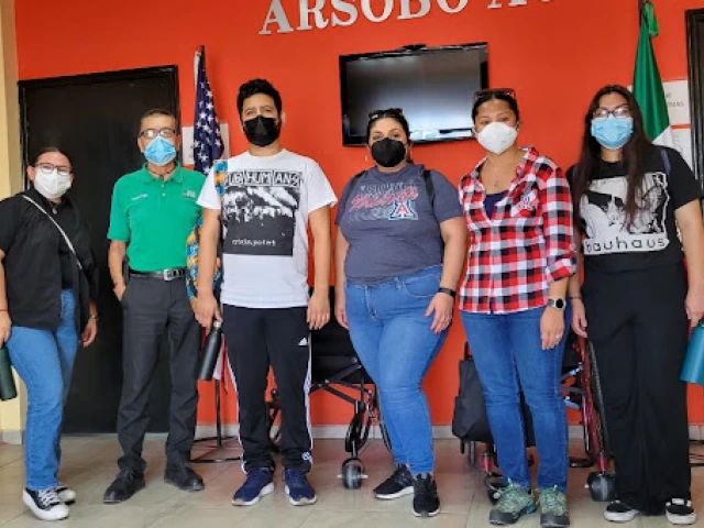  Fellows are posing alongside ARSOBO Executive Director, Kiko Trujillo and Sonoran Center for Excellence in Disabilities staff, Celina Urquidez and Jacy Farkas. Left to right: Paulette Nevarez is wearing a black shirt with a black button up over with blue jeans and black shoes, Kiko Trujillo is wearing a green polo with black pants and black shoes, Abraham Venegas is wearing a white shirt with a graphic with black pants and black shoes, Celina Urquidez is wearing a gray shirt with the A for UA