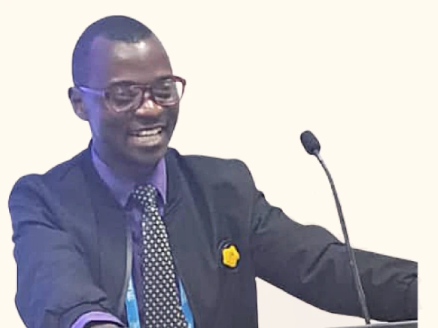 Harunah Damba, chairperson of UPWD, in a suit speaking at a podium