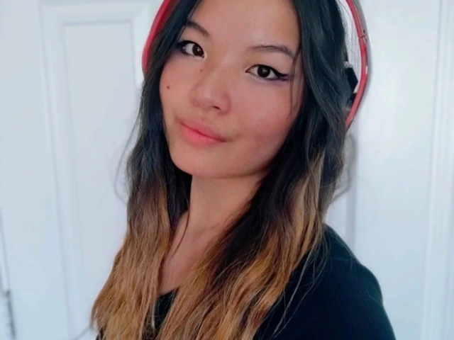 Kai Glahn, a young person with long dark hair with brown highlights, wearing read headphones