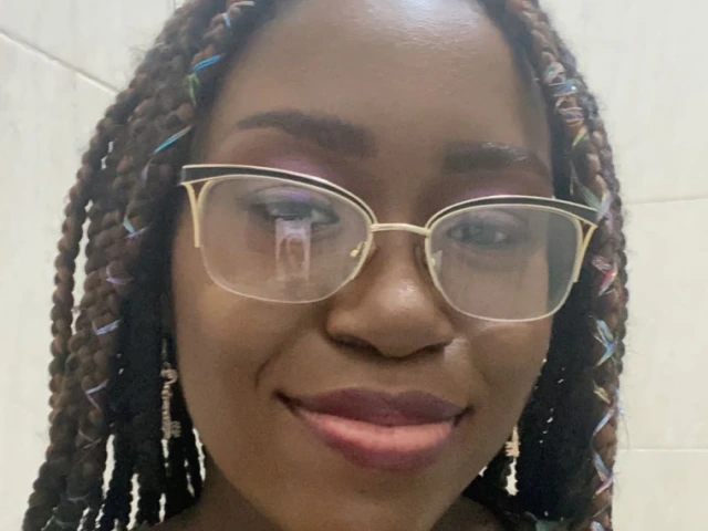 Sylvia Badger, a young woman with braided hair, wearing a blue top, with a slight smile