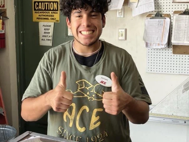 Student worker Esteban gives two-thumbs-up after being offered a job at ACE Hardware. 
