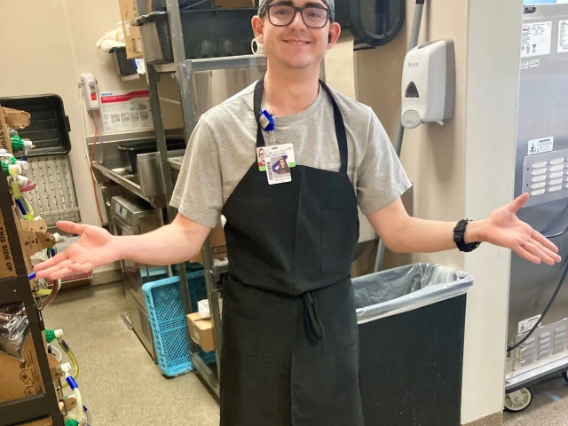 Cole wearing a uniform and apron ready for work