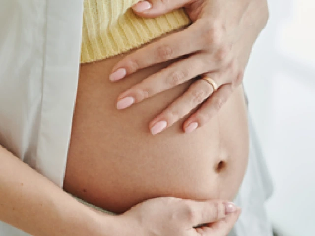 Photo of woman holding her pregnant belly