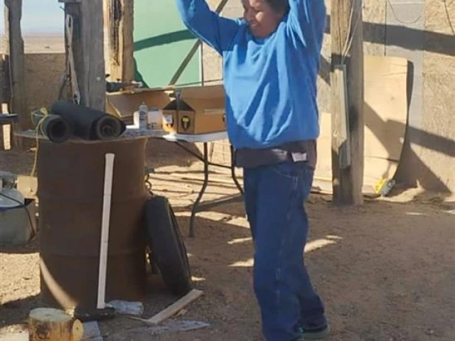 A person chopping wood outside, swinging an axe