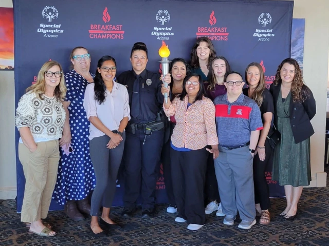 Sonoran Center staff and a TPD representative stand with the Torch