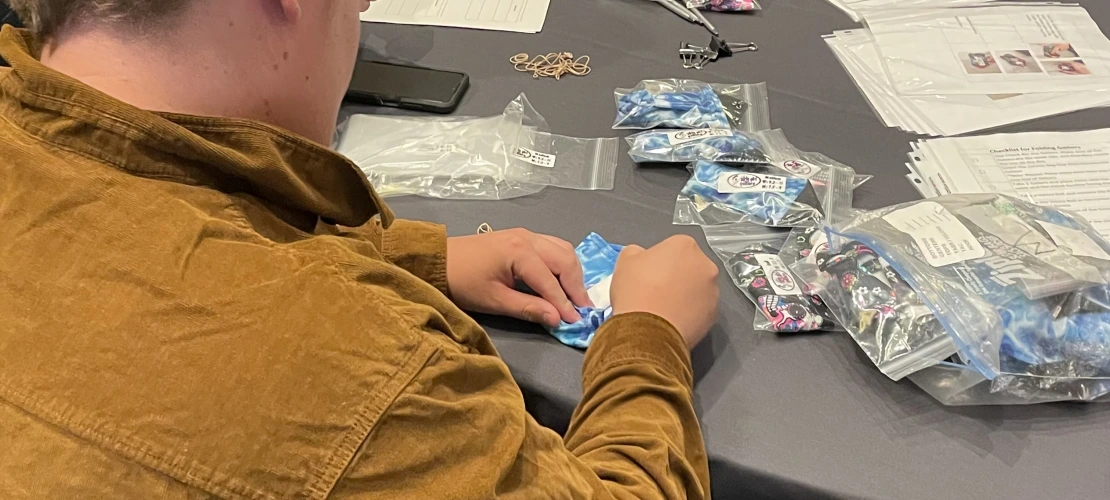 Over the shoulder of someone folding cloth.
