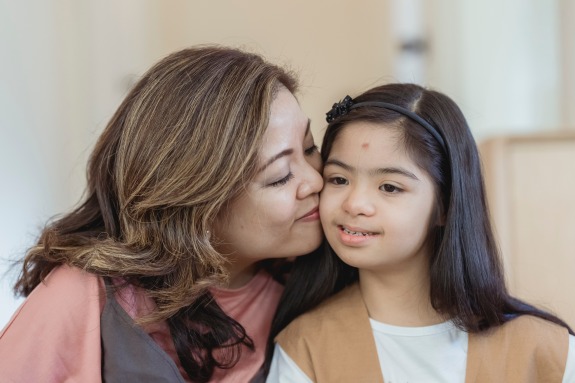 Portrait of Mother Kissing her Special Needs Daughter