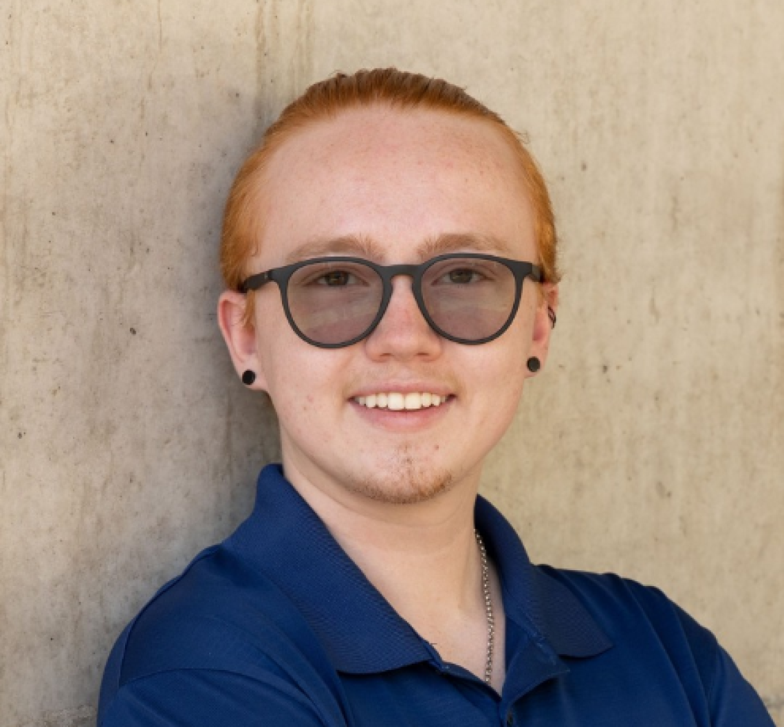 Austin Randall, author of this article. A white person with short red hair wearing glasses and a blue collared shirt.