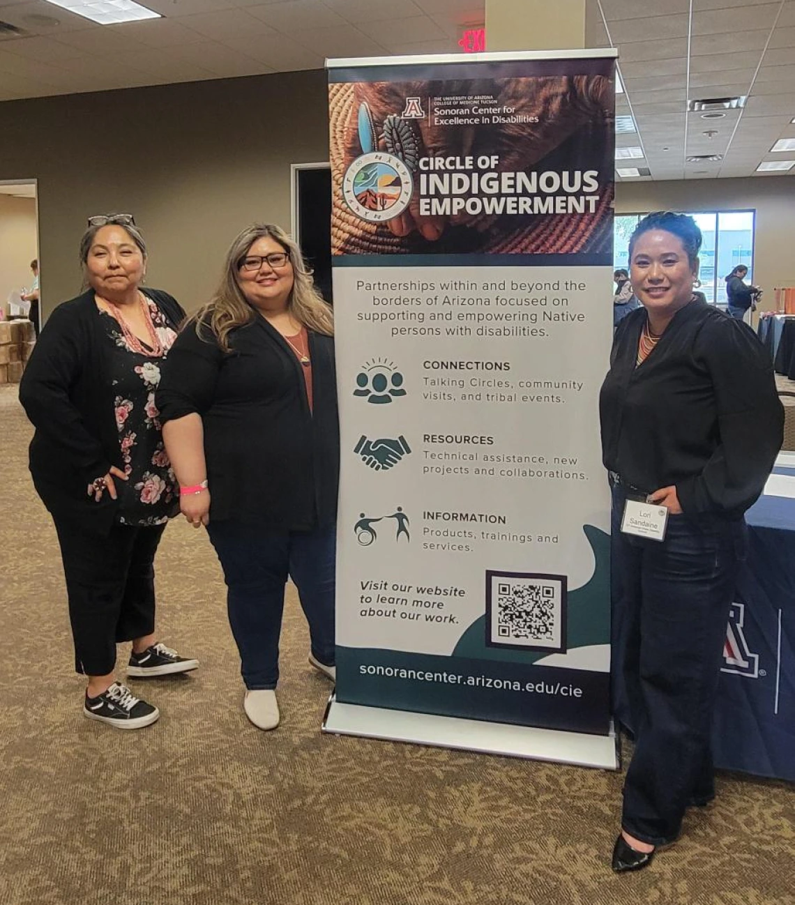 Left to right: Agnes Attakai, Rosa Rojas-Franco, and Mỹ Lê Sandaine stand next to a banner for the Circle of Indigenous Empowerment