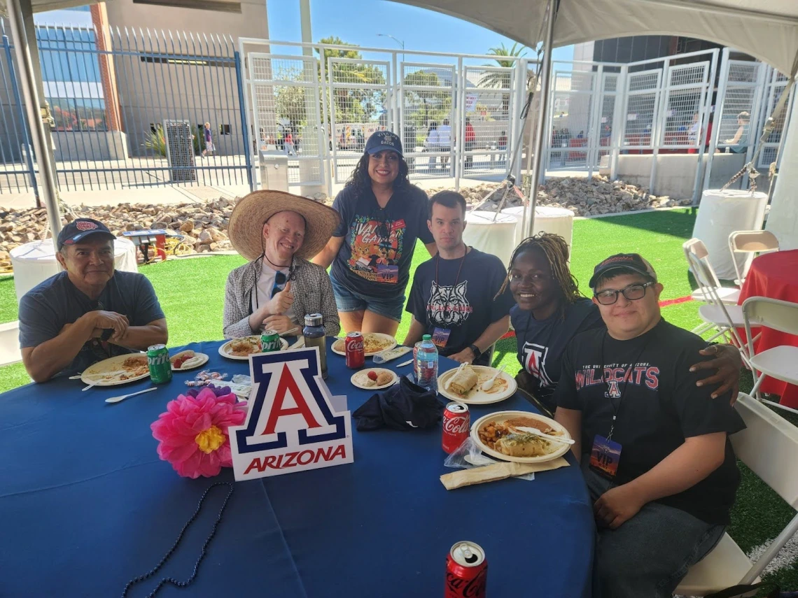Professional Fellows Mai and Kelvin with Sonoran Center staff in U of A merchandise