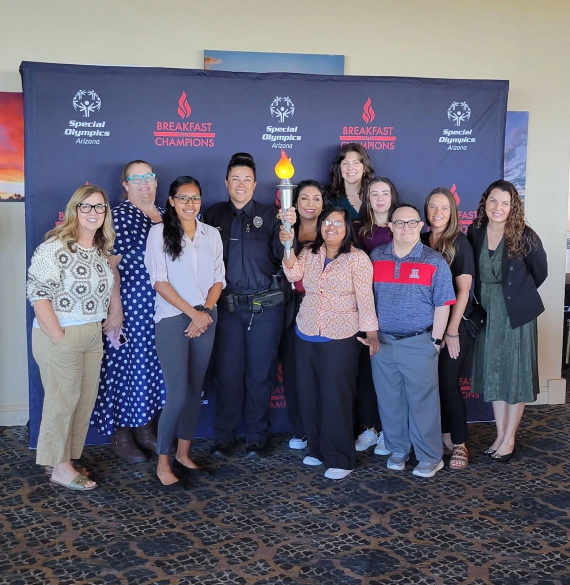 Sonoran Center staff and a TPD representative stand with the Torch