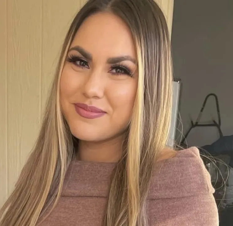 Alexis, smiling woman with long brown hair with blonde highlights