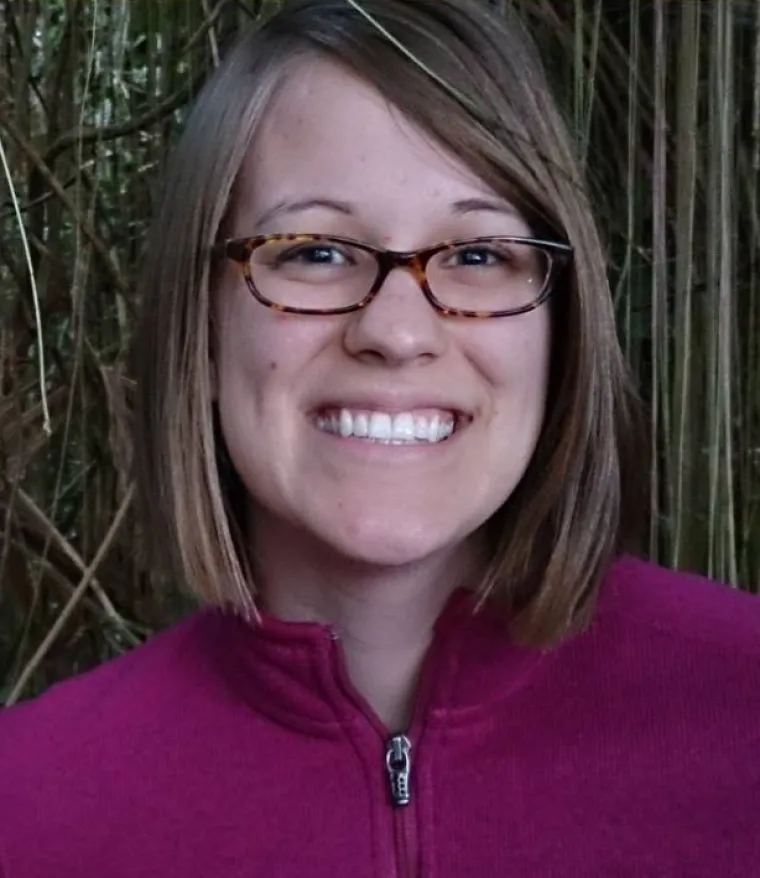 Woman with short hair and glasses smiling