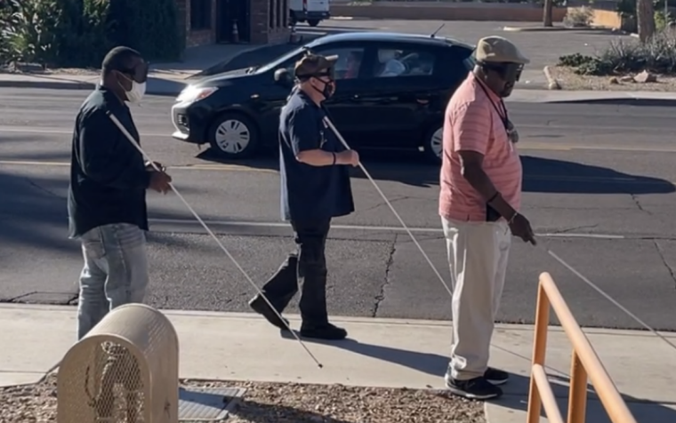 Three SAAVI students demonstrate their Orientation and Mobility skills on a Tucson street sidewalk with their canes and learning shades