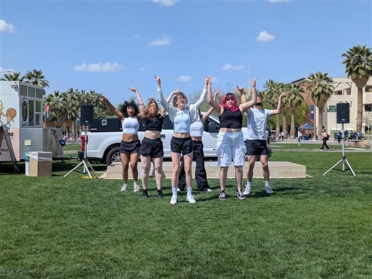 UnderSkore in formation, holding up their hands during their dance performance. 