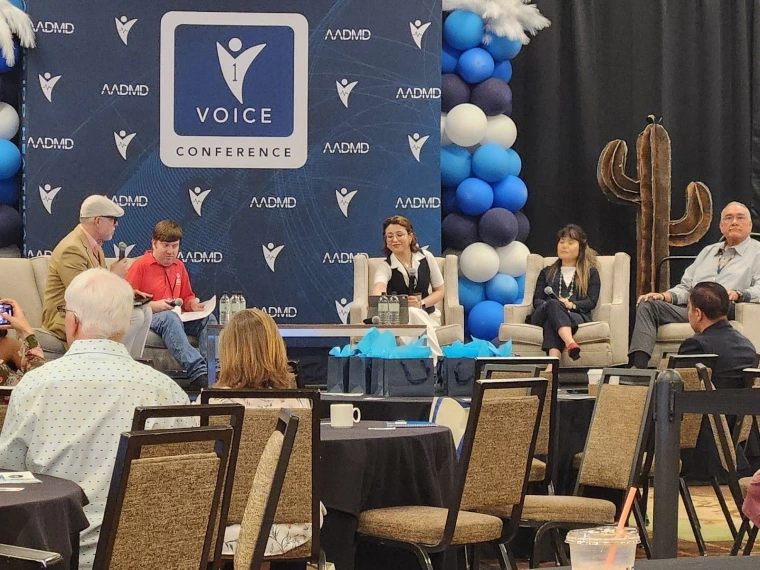 Jim Warne sits with co-panelists, listening as the moderator asks a question. 
