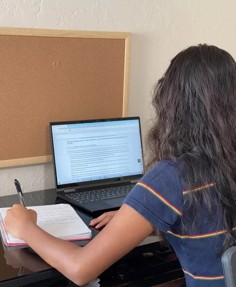 Esha Mathur taking notes on a state health policy