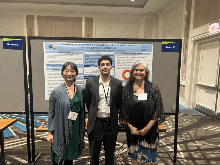 Yumi Shirai, Nicholas Amjadi, and Michelle Thompson smiling in front of their poster