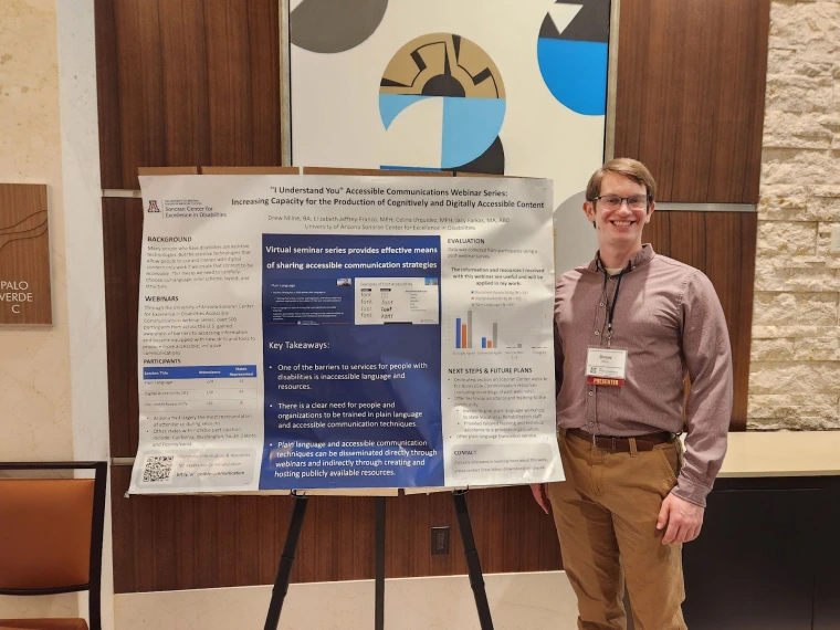 Drew Milne smiling for a picture with his poster on the Accessible Communication Webinar Series