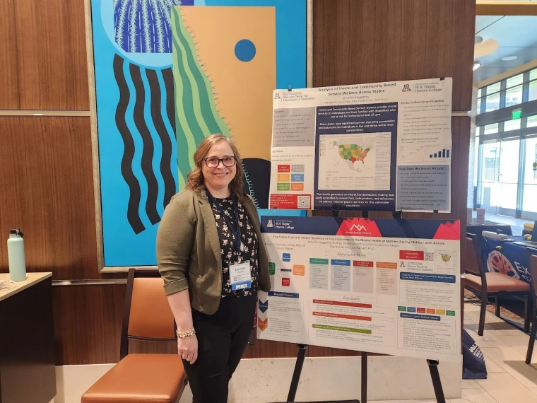 Jennifer Haggerty smiling for a picture with her poster on HCBS waivers. 