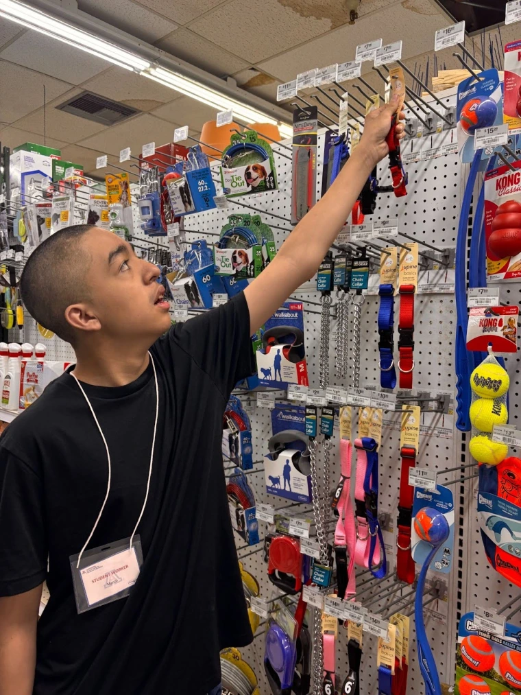An employee participant stocks shelves at a hardware store