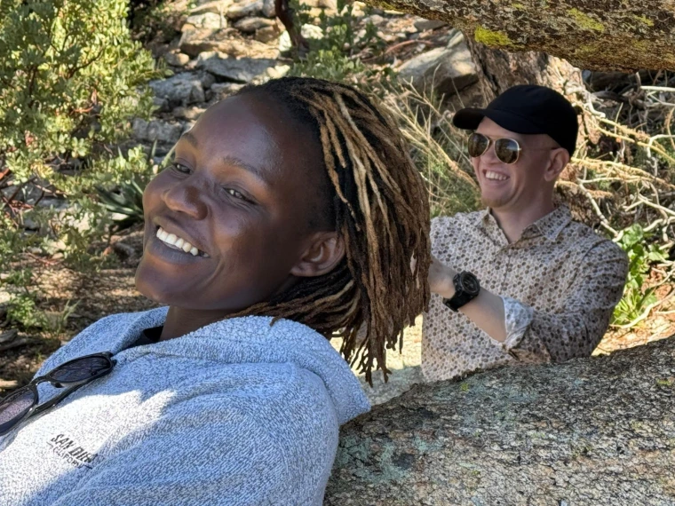 Mai and Kelvin smile while they stop for rest beneath a shaded rocky outcrop on Mount Lemmon
