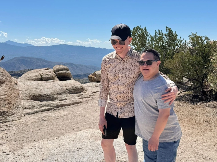 Kelvin and Gabe embrace at the summit of Mount Lemmon