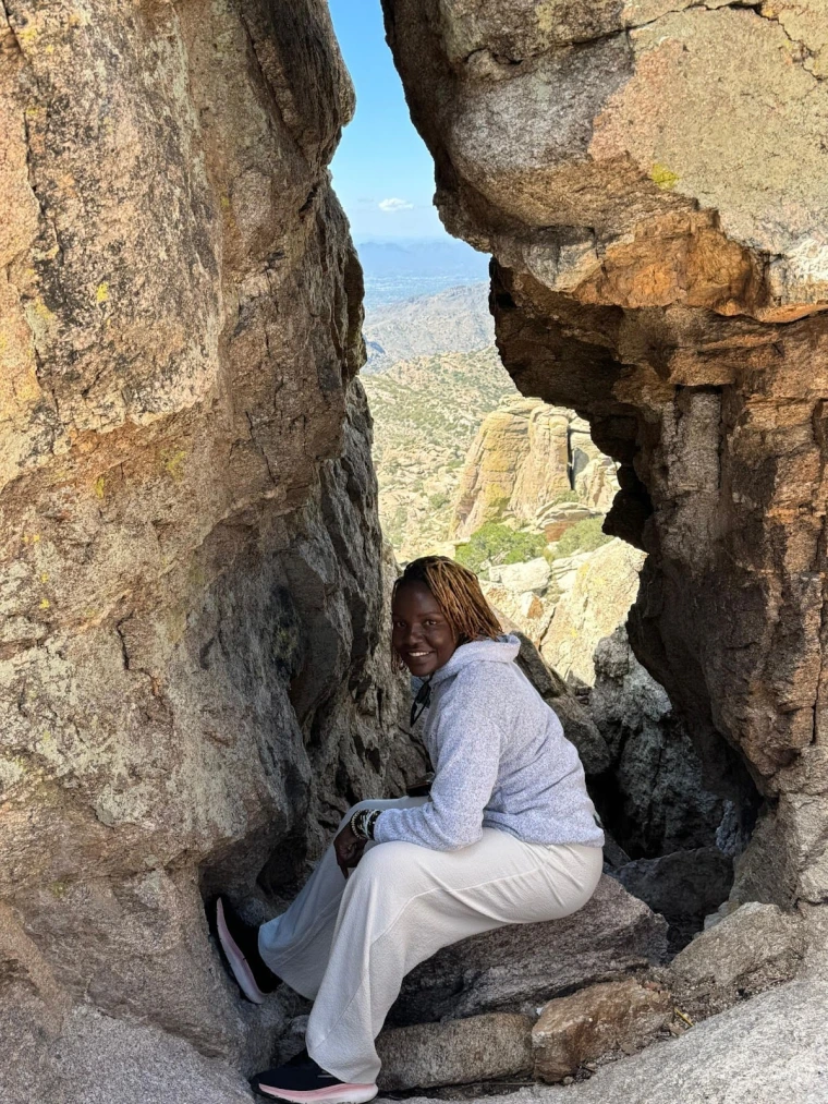 Mai poses for a photo in a narrow ravine on Mount Lemmon