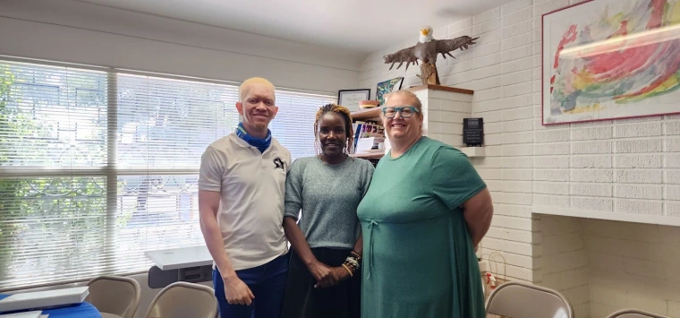 Mai, Kelvin, and Danielle standing in front of a window in the Sonoran Center office and smiling for a photo. 