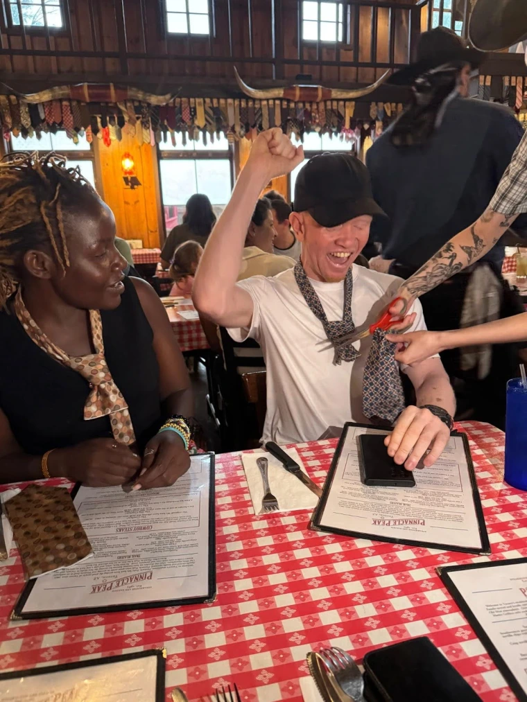 Kelvin cheers while his tie is cut off at Pinnacle Peak while Mai looks on