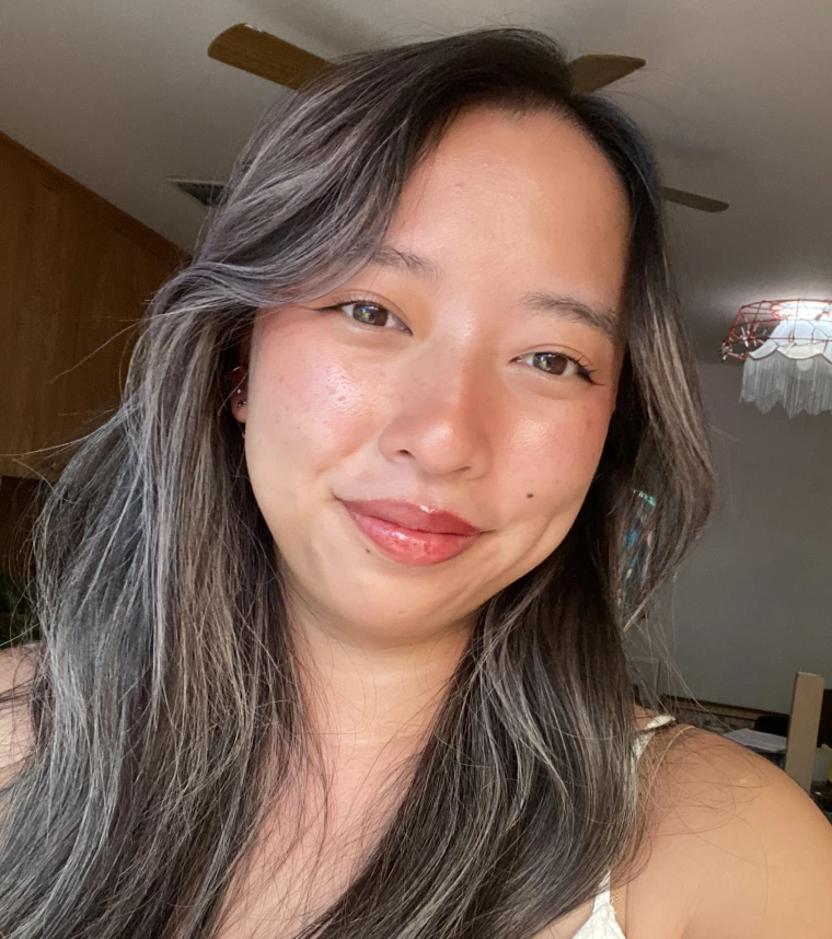 young woman with long brown hair, she is smiling at the camera