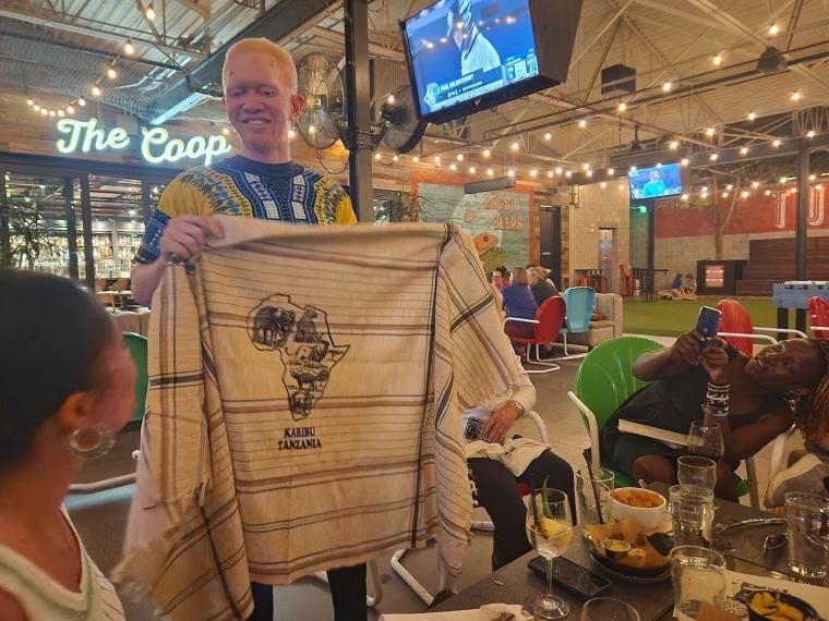 Kelvin at Culinary Dropout showing a cloth that says ‘Karibu Tanzania’