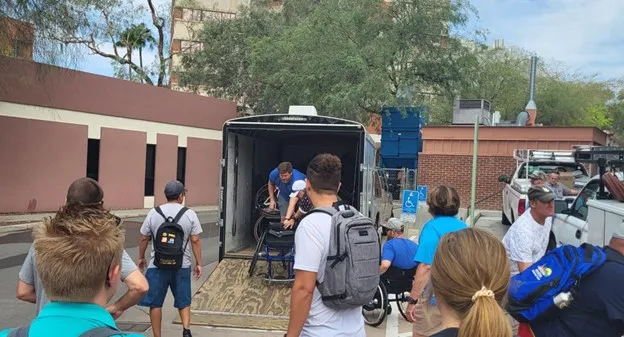 volunteers distribute the wheelchairs from a truck.