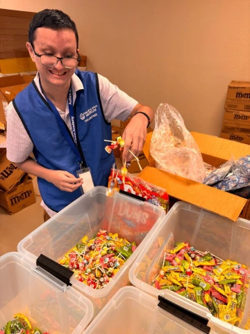 A WBLP participant smiles as he sorts candy for the Pima Air and Space Museum's Halloween event